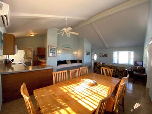 A spacious living area with a wooden dining table, a sofa, and a ceiling fan. - HILLSIDE TWO BEDROOM VILLA - OCEANVIEW (Georgetown)