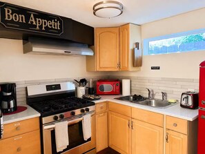 A compact kitchen with a stove, oven, microwave, and a red refrigerator. - Private Guesthouse – Quiet & Cozy (Dallas)