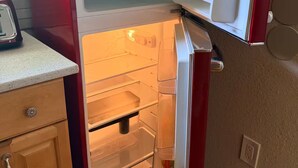 Una cocina equipada con un refrigerador, un microondas y un tostador.