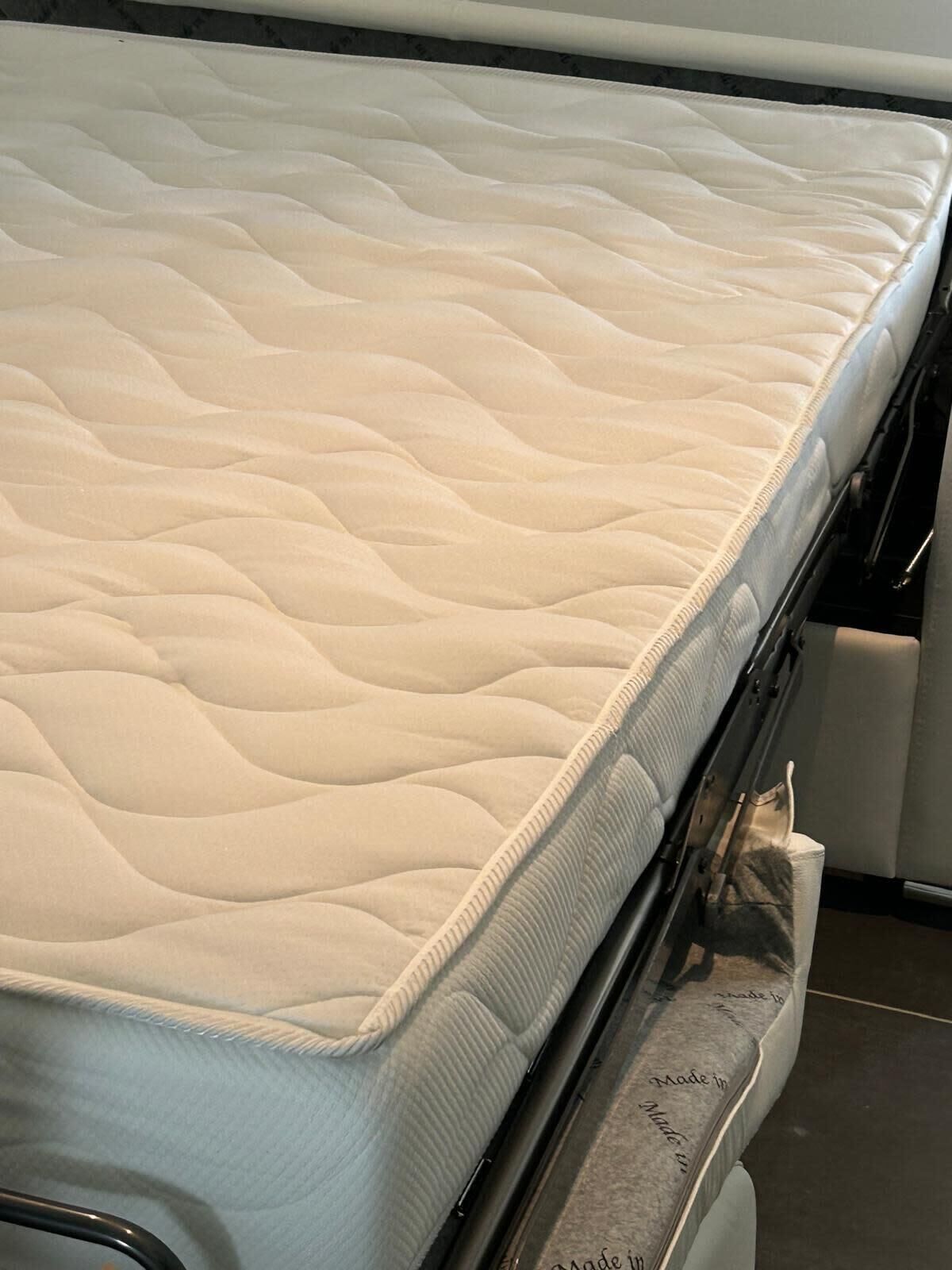 A mattress with a quilted top and a metal frame.