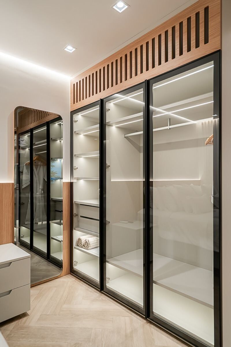 A walk-in closet with sliding doors, shelves, and a hanging rod.