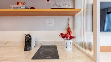 A kitchen with a built-in stove, a coffee machine, and a spice rack.