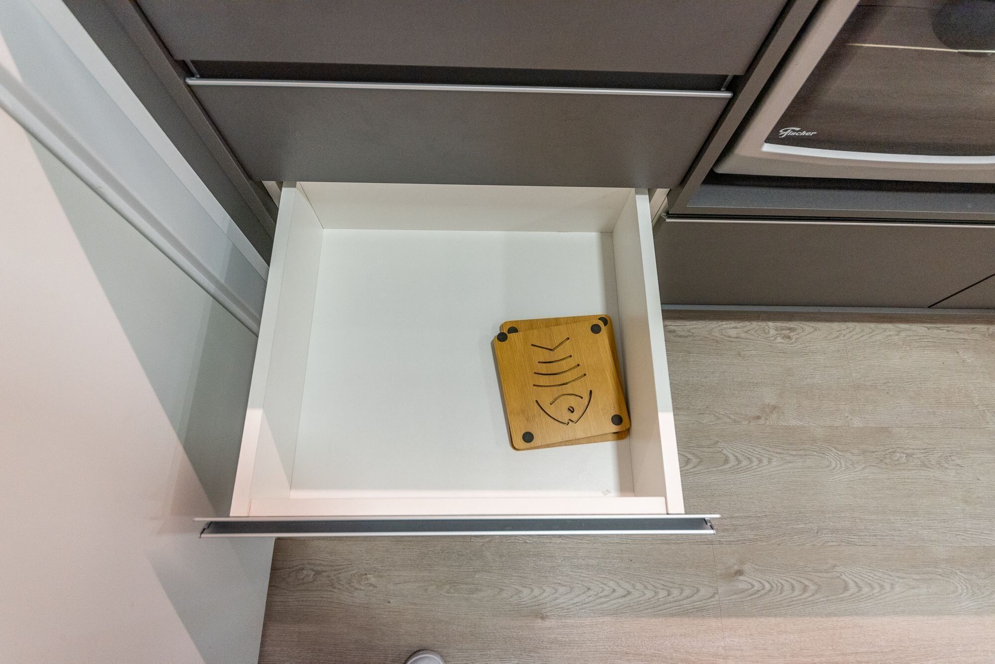 A kitchen drawer with a wooden utensil holder.