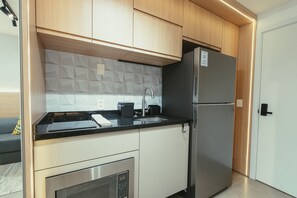 A modern kitchen with wooden cabinets, a stainless steel refrigerator, and a built-in dishwasher. - GO24 by LikeHome (Porto Alegre)