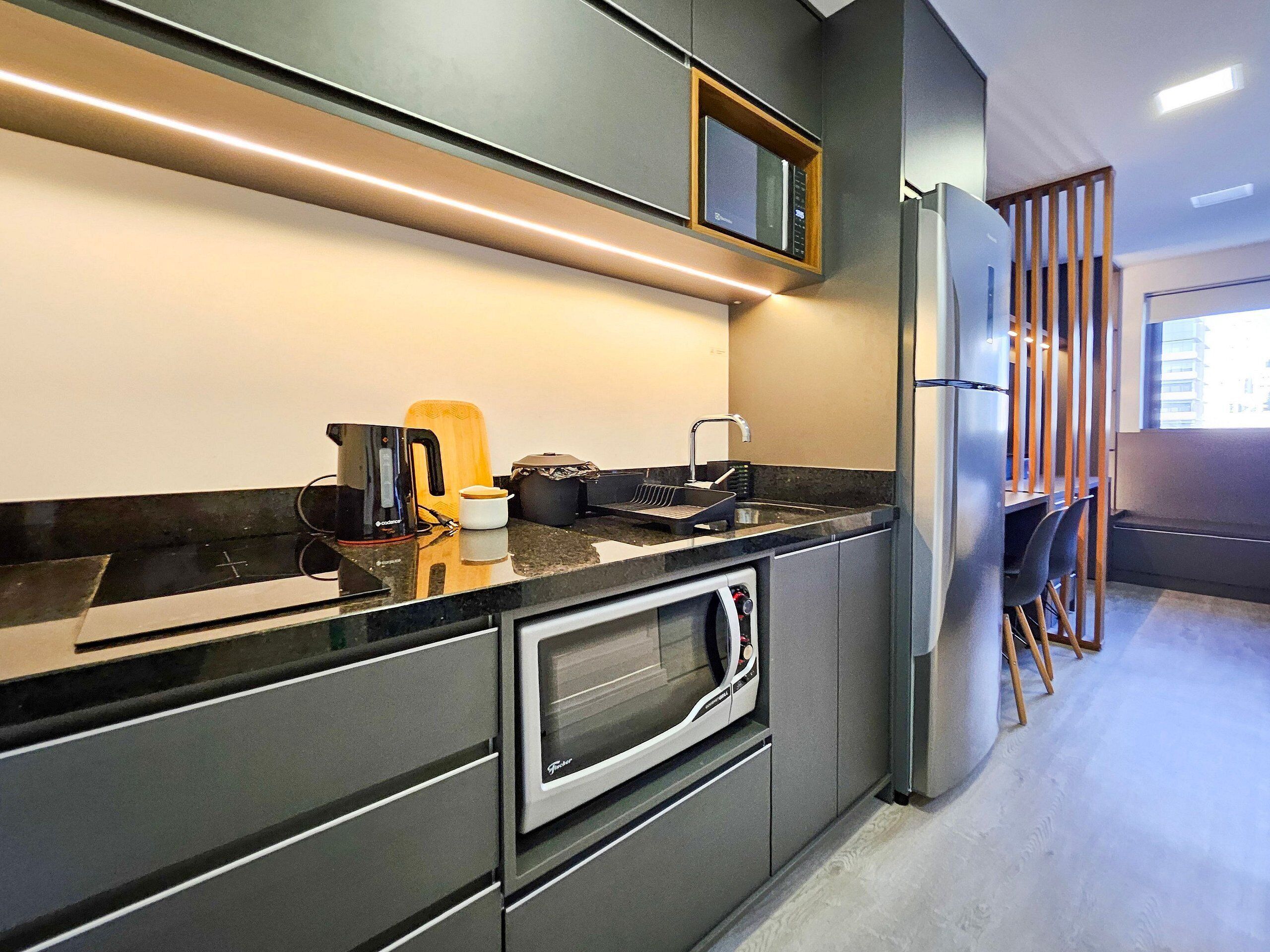 Una cocina moderna con horno integrado, cafetera y microondas.