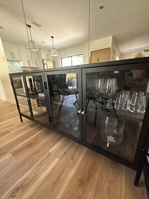 A modern kitchen with a black glass cabinet, wooden flooring, and pendant lighting. - Cocoa Beach its Best, Bring FIDO! (Cocoa Beach)