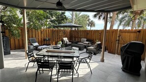 A covered patio with a table, chairs, and a grill. - Cocoa Beach its Best, Bring FIDO! (Cocoa Beach)