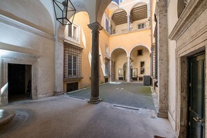 An interior courtyard with a fountain, columns, and a tiled floor. - Banchi Fontana - Castel Sant Angelo (Rome)