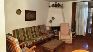 Een woonkamer met een bank, fauteuil en een klein tafeltje.