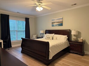 A bedroom with a large bed, two bedside tables with lamps, a desk, and a chair. - Pink Par-Tee Villa   Luxe Beach Getaway with Golf Cart (Murrells Inlet)