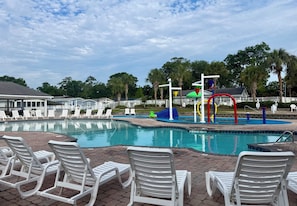 A swimming pool with lounge chairs and a water slide. - Pink Par-Tee Villa   Luxe Beach Getaway with Golf Cart (Murrells Inlet)