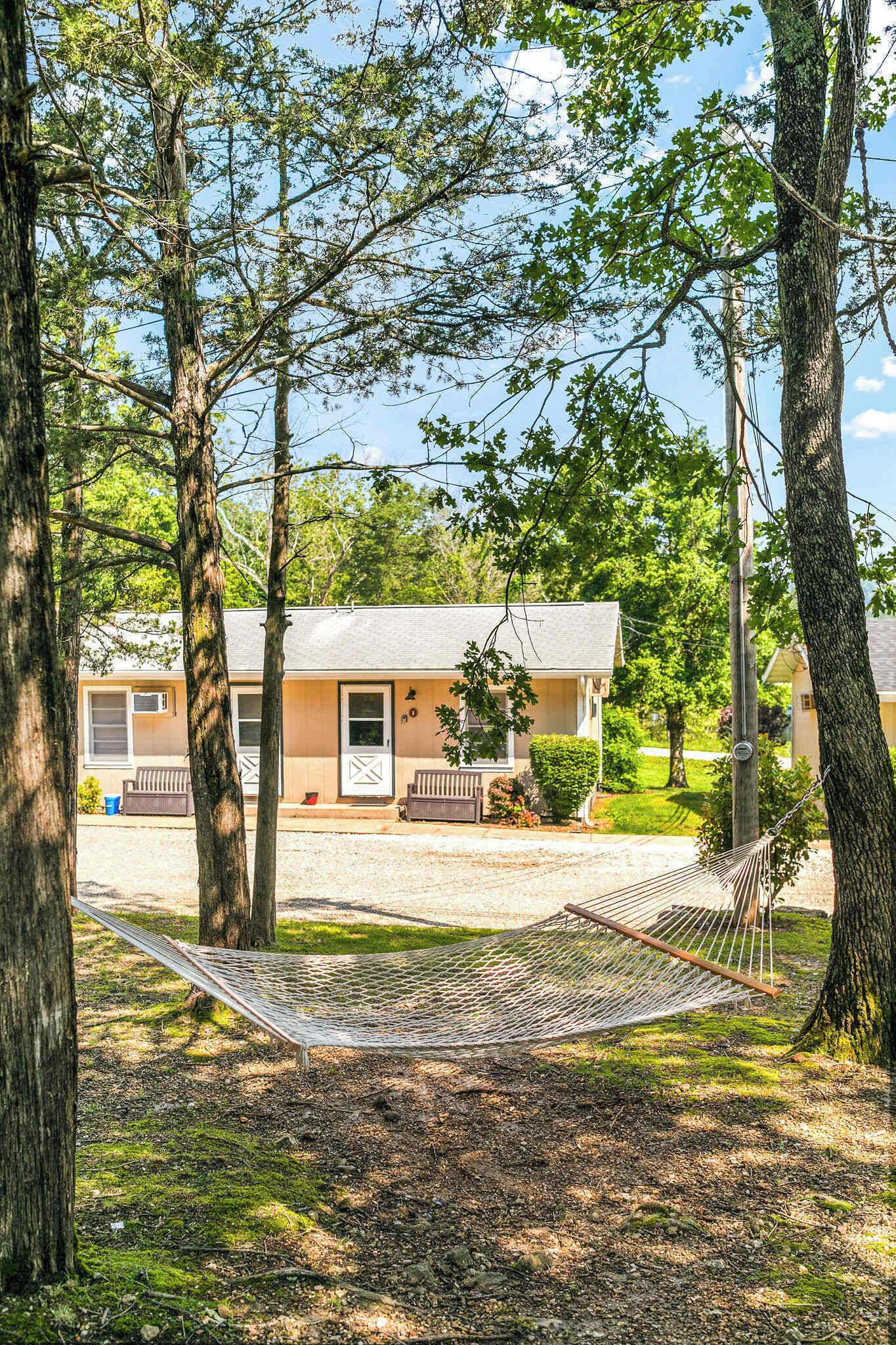 A house with a porch, a hammock, and a driveway.