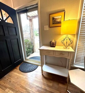 A room with a wooden floor, a white desk with drawers, a lamp, and a framed picture on the wall. - Mackey Park Retreat! (Lubbock)