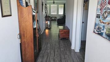 A hallway with wooden flooring, a wooden cabinet, a framed certificate, and a sign reading 'Family Country.'