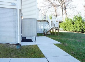 Una propiedad residencial con garaje, una escalera exterior techada y un césped bien cuidado.