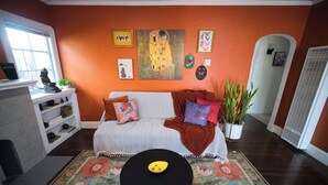 A cozy living room with a sofa, a coffee table, and a variety of decorative items. - Charming 1920s Westbrae Berkeley Cottage with Soaking Tub! Walk to BART & Parks (Berkeley)