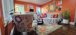 Un salon comprenant un canapé, un fauteuil, une table basse et une grande plante en pot.