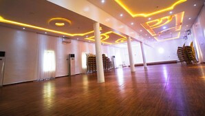 Un hallo espacioso con suelo de madera, paredes blancas e iluminación circular en el techo.