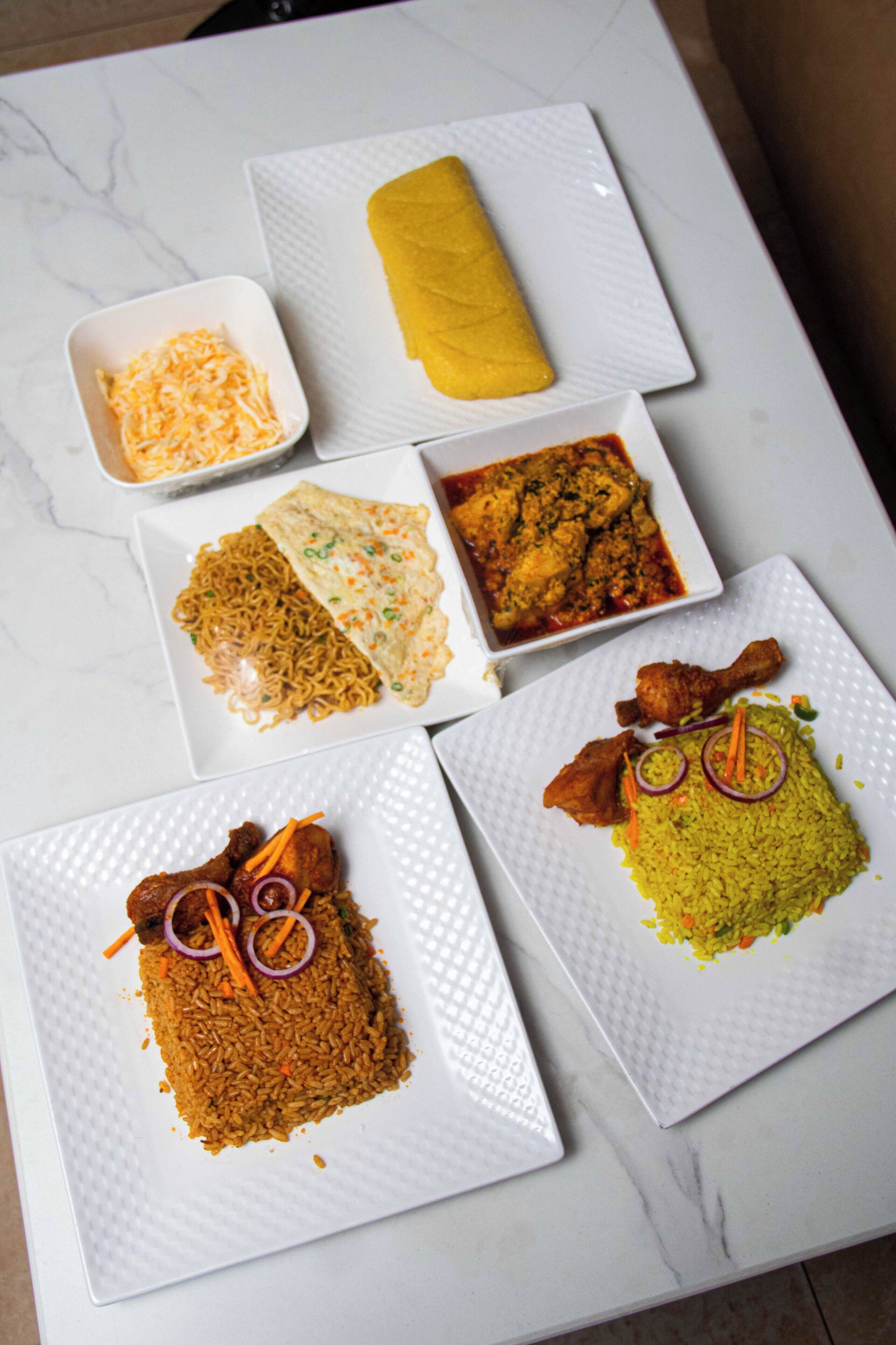 A table with various dishes including noodles, fried rice, and a rolled omelette.