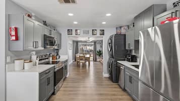 A modern kitchen with stainless steel appliances, grey cabinetry, and a central island.
