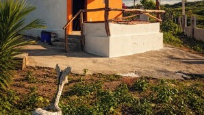 A single-story building with a red-tiled roof, a porch with wooden railings, and a small garden area with a decorative giraffe statue. - Chalé do Arisco (Cerro Corá)