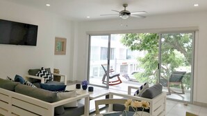 A modern living room with a sofa, a dining table, and a ceiling fan. - Relaxing Apt in SJDS – A Short Walk to the Beach (San Juan del Sur)