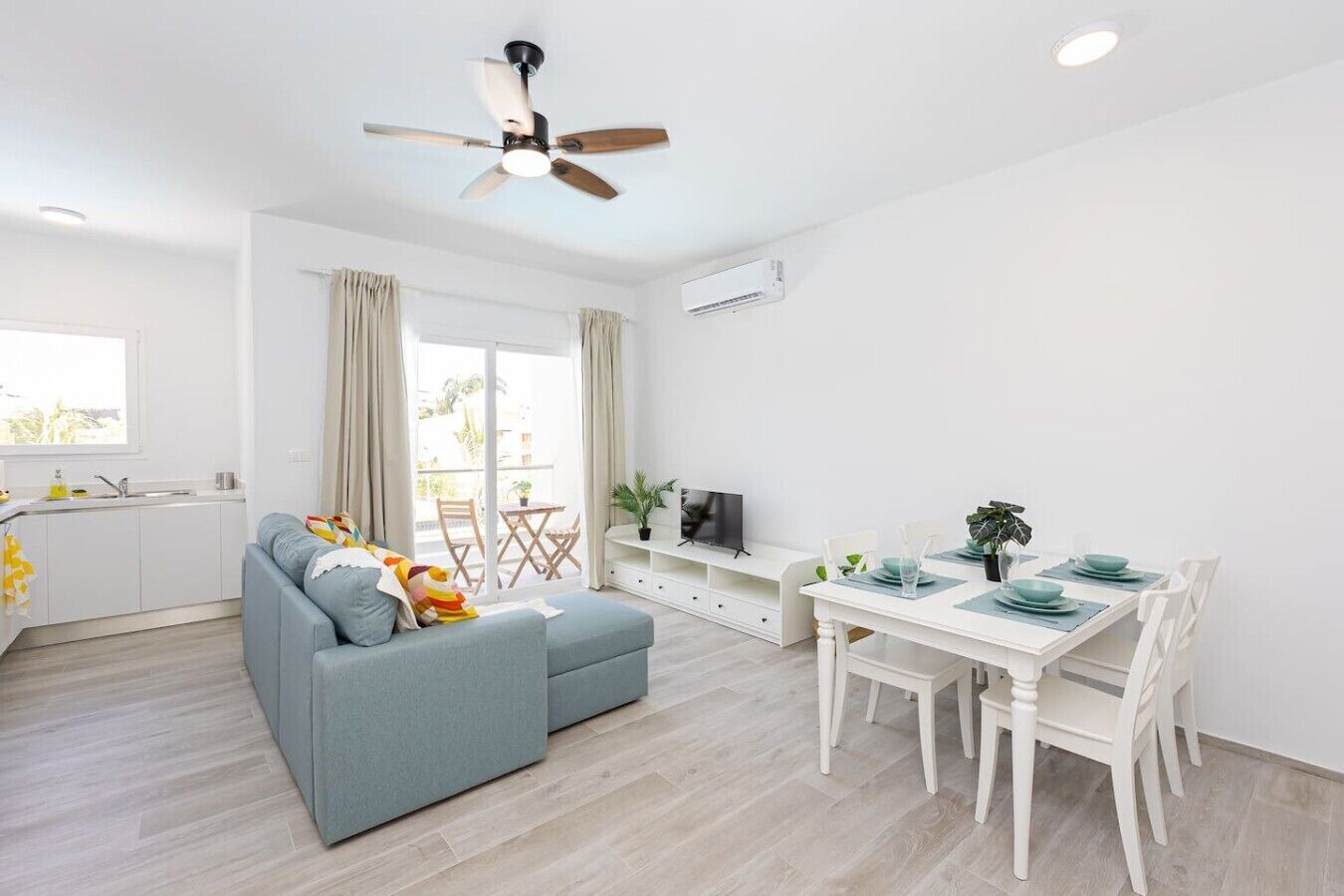 Una sala moderna con sofá, mesa de comedor y sillas.