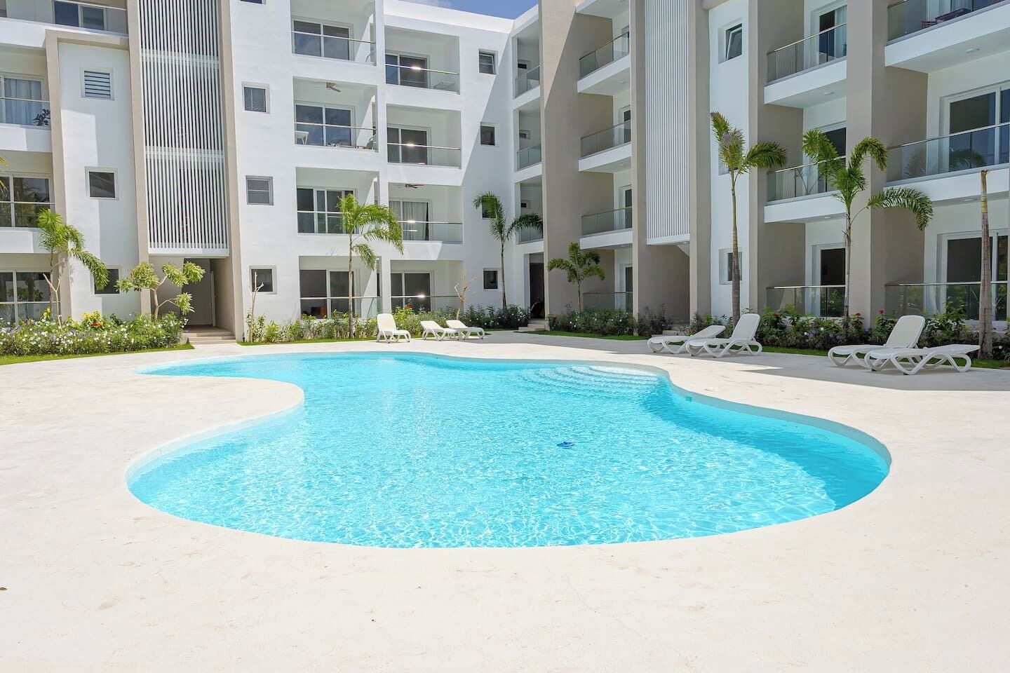 Un edificio moderno con piscina y tumbonas.