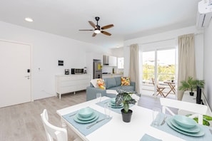 A modern apartment with a dining area, kitchen, and living space.