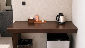 A kitchen with a countertop, a coffee maker, a trash bin, and a refrigerator. - ARIMATABE Beachfront Resort (Koh Rong)