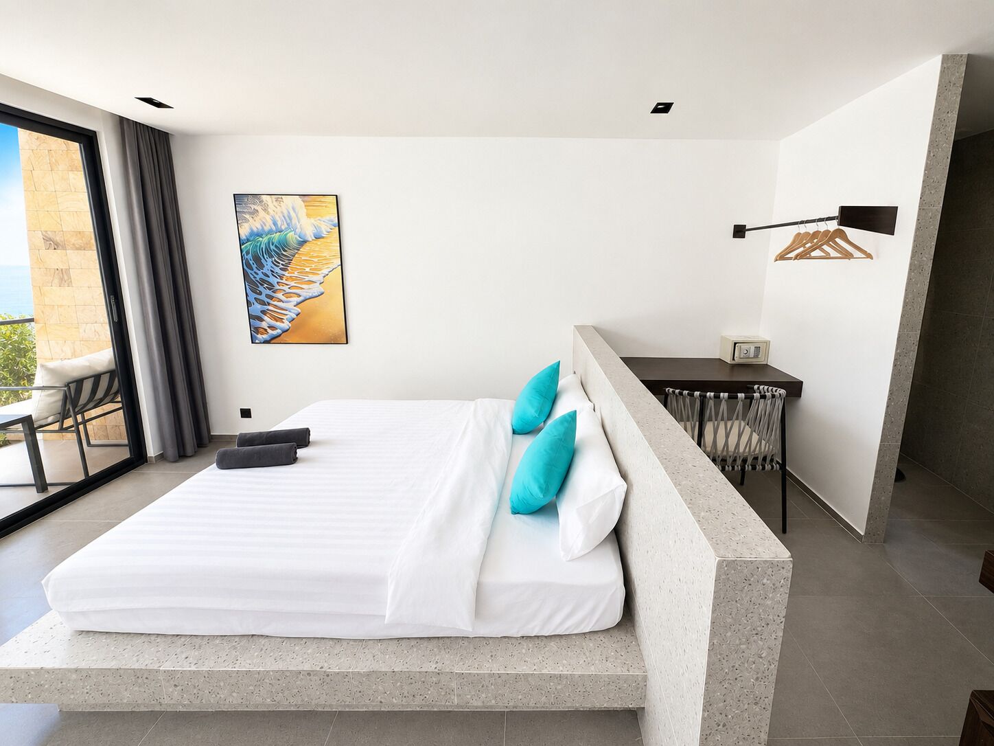 Une chambre moderne avec un grand lit, un bureau et une vue sur l’extérieur.