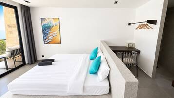 Une chambre moderne avec un grand lit, un bureau et une vue sur l’extérieur.