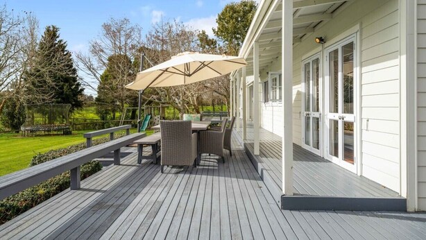 Una terraza cubierta al aire libre con mesa y sillas, una mesa de picnic y una pérgola.