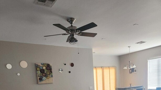 A living room with a sectional sofa, a ceiling fan, a dining area with a table and chairs, and a window with blinds. - Sierra Vista Hideaway / 5 minutes to Fort Huachuca (Sierra Vista)