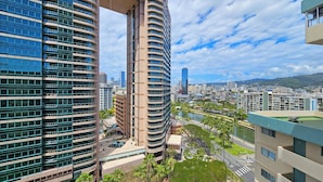 Un edificio alto con facciata curva, un'ampia vetrata e vista su un paesaggio urbano con altri edifici e una distesa d'acqua.