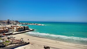 A coastal cityscape with a beach, buildings, and a clear blue sky. - Cozy Oceanfront 1BR Studio Sonoran Star (Puerto Peñasco)