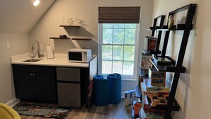 A compact kitchen with a microwave, sink, and window. - Premium Waterfront 5BR/3.5BA. Boat House, Kayaks, Lillypad, Wheelchair-friendly (Littleton)