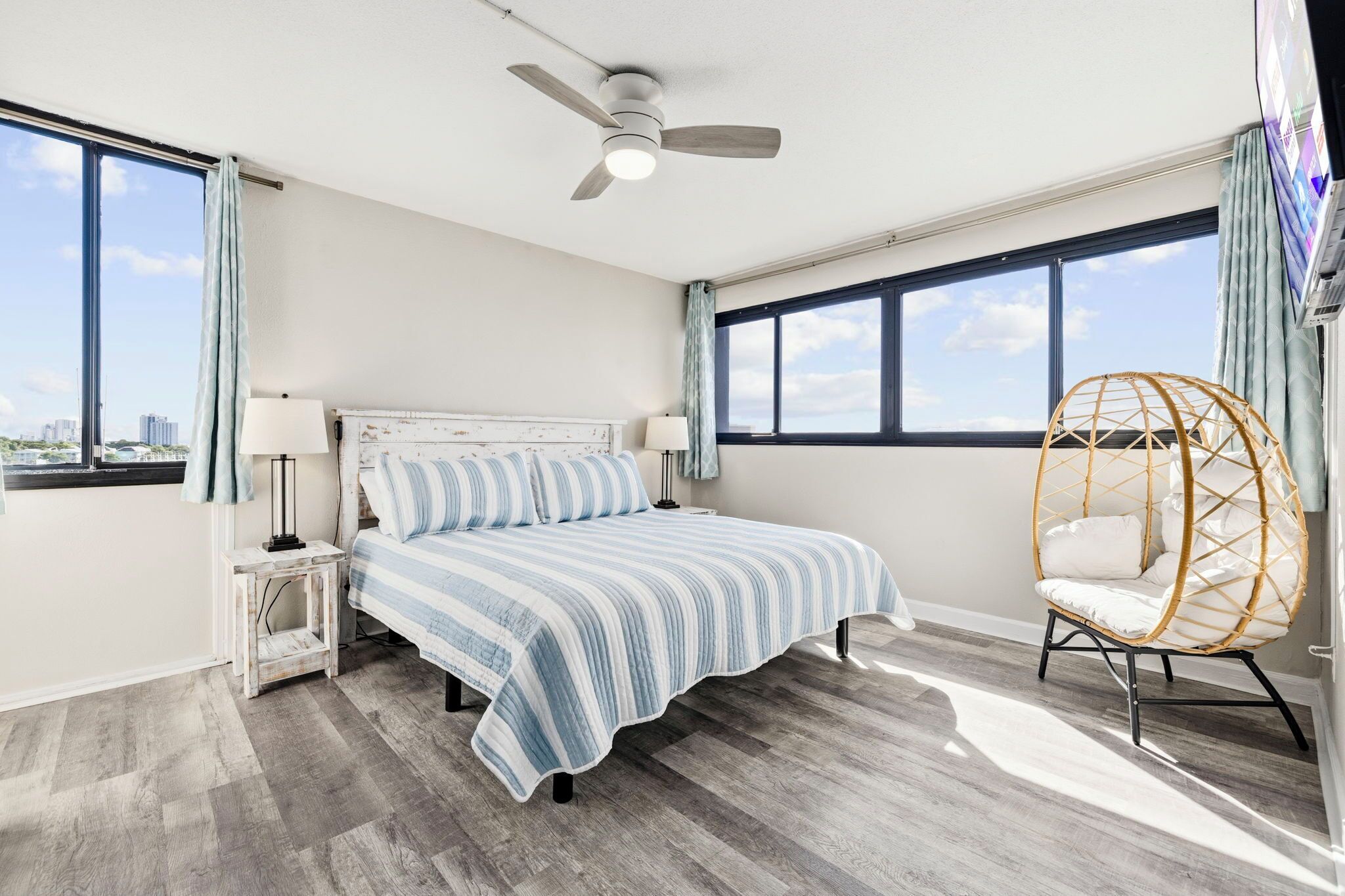 A bedroom with a bed, a ceiling fan, a window, and a chair.