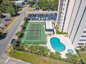 An aerial view of a residential building with a tennis court, swimming pool, and parking lot. - Family Condo: Ocean View + King Bed + Hot Tub + Pool (Myrtle Beach)