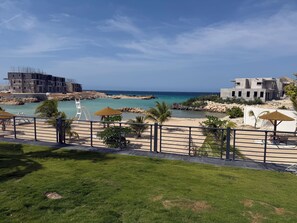A coastal view with a beach, a pool, and a building under construction. - Velvet at Paradisiac/Private Beach, Pool & Gated Luxury (Llandovery)