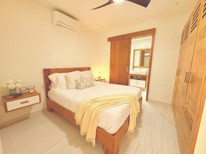 Ein Schlafzimmer mit Bett, Nachttisch und Spiegel.