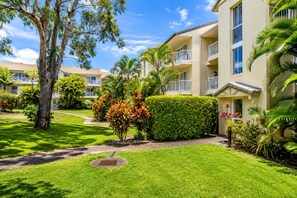 A multi-story hotel with balconies, a well-maintained lawn, and tropical landscaping. - The Burleigh Hideaway (Gold Coast)