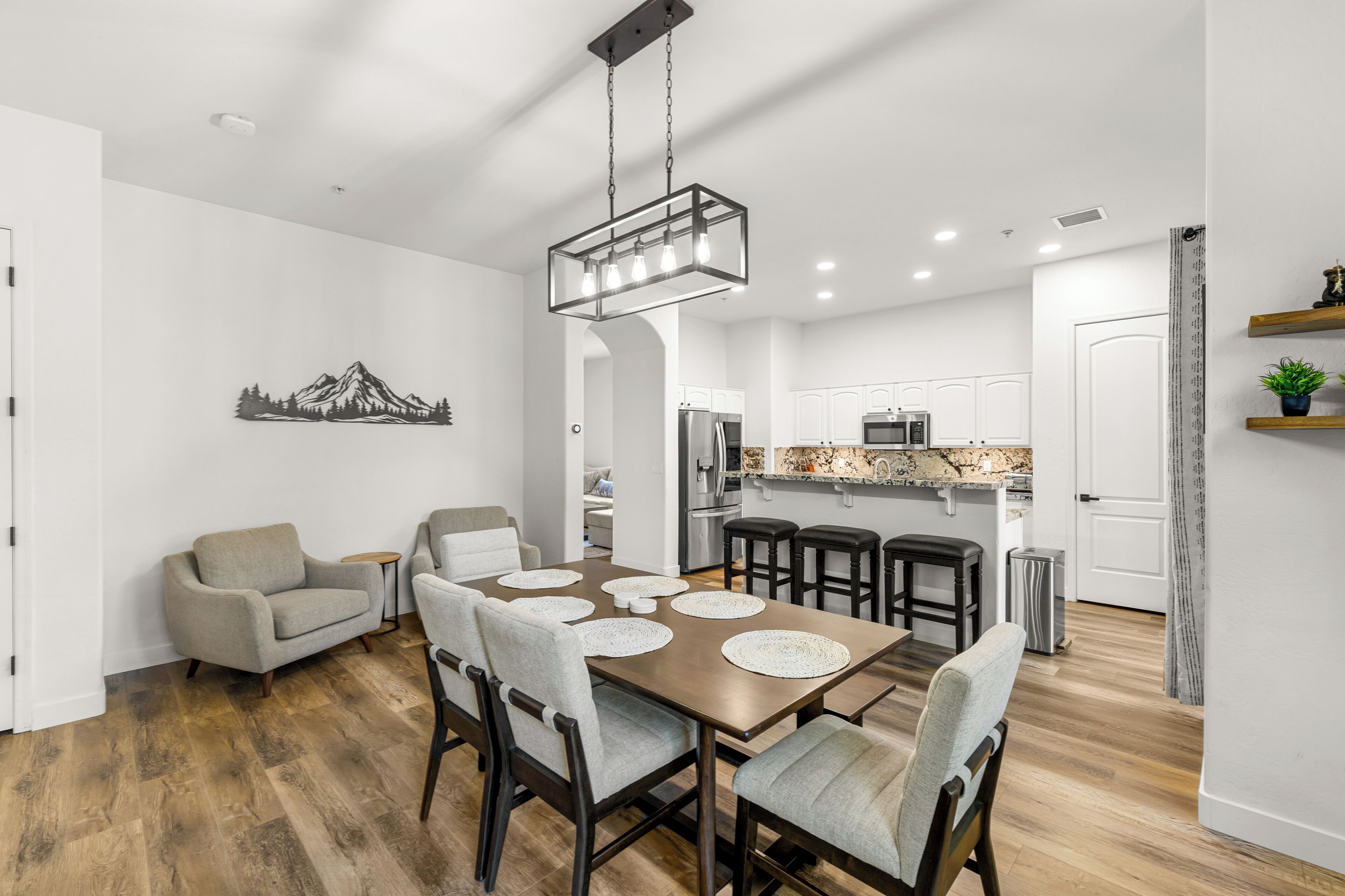A modern kitchen with white cabinets, a stainless steel refrigerator, and a granite countertop.