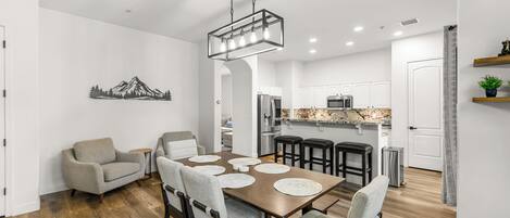 A modern kitchen with white cabinets, a stainless steel refrigerator, and a granite countertop.