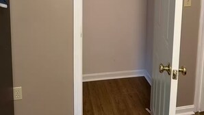 A closet with a hanging rod and a door with a brass handle. - Nestled in the trees. (Saco)