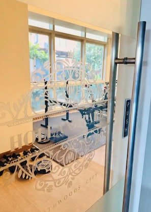 A room with a large window, a metal door with a push bar, and a decorative metal partition. - Enjoy a cozy and minimalist unit in the heart of Southwoods, Biñan. (Binan)