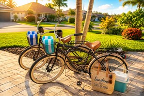 Een fiets met een mandje en tas, geparkeerd op een verharde ondergrond met beplanting en huizen op de achtergrond.