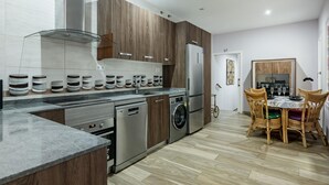 A modern kitchen with a built-in oven, washing machine, and refrigerator. - Madrid Centro - 3 bedroom and 2 bathroom apartment with 2 terraces (Ciudad de Madrid)