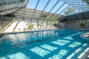 An indoor swimming pool with clear water, a covered roof, and potted plants. - 6 Barrett Place | Elevated Luxury in the Heart of Rosemary Beach (Rosemary Beach)