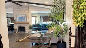 Amplia sala de estar con chimenea, comedor y vista a otra habitación.